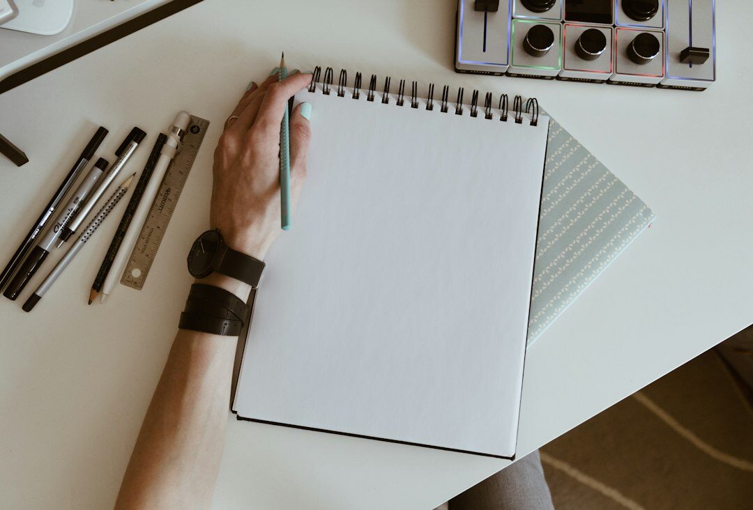 man writing in notebook